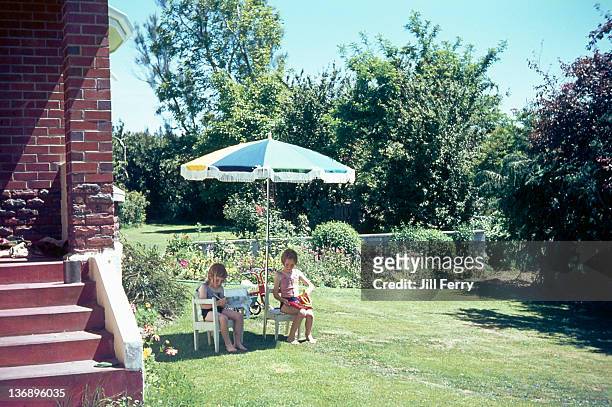 sitting under umbrella in summer - sentriesvintage stock pictures, royalty-free photos & images