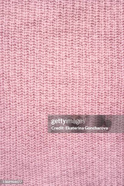 close-up of a knitted fabric, part of a sweater or other hand-knitted clothing. - knitted stock pictures, royalty-free photos & images
