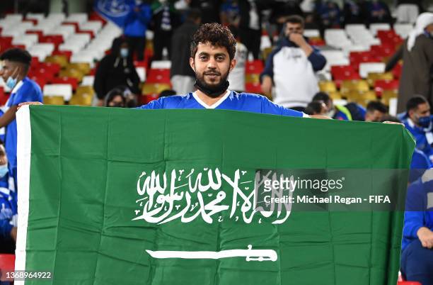 An Al Hilal fan hold the flag of Saudi Arabia prior to the FIFA Club World Cup UAE 2021 2nd Round match between Al Hilal and Al Jazira at Mohammed...