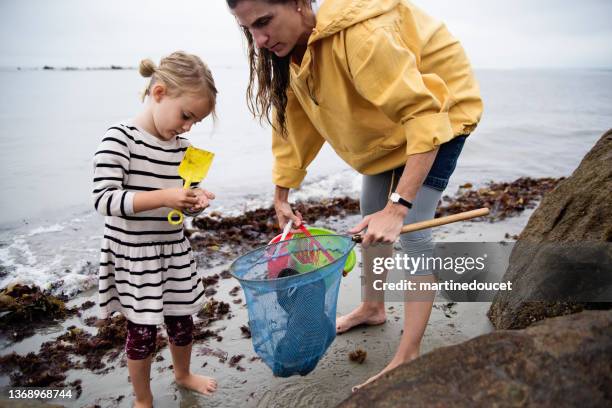 mother and daughter on beach on overcast day. - mother daughter beach stock pictures, royalty-free photos & images