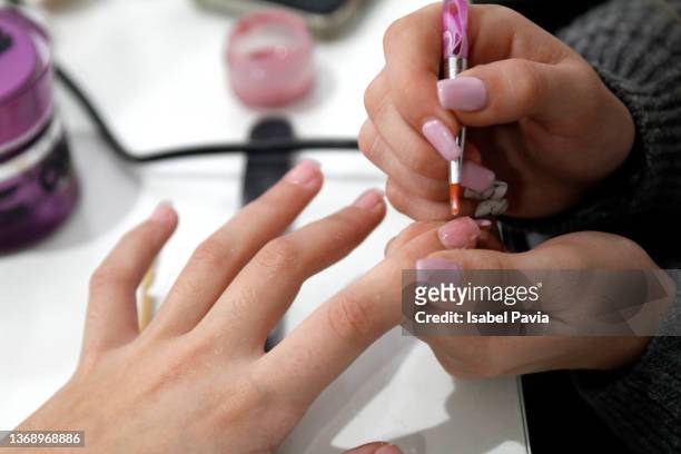 close-up of woman making a beauty treatment for nails - nagelkunst stockfoto's en -beelden