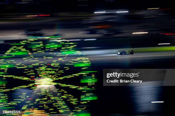 The Cadillac Dpi of Loic Duval, Ben Keating, Tristan Vautier and Richard Westbrook races down the back straight in the early morning hours during the...