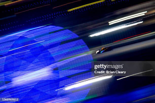 Prototype race car speeds past the ferris wheel in the early morning hours during the Rolex 24 during the IMSA WeatherTech Series race at Daytona...