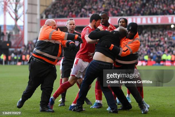 Fan is apprehended on the pitch after attacking a Nottingham Forest player during the Emirates FA Cup Fourth Round match between Nottingham Forest...