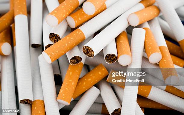 cigarettes randomly piled in a large heap - cigarette stock pictures, royalty-free photos & images