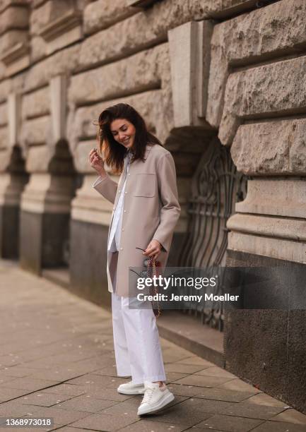 Ira Meindl wearing Chanel red leather bag, Alexander McQueen white platform sneaker, Aspesi white flannel and white pants, Manzoni 24 beige jacket...