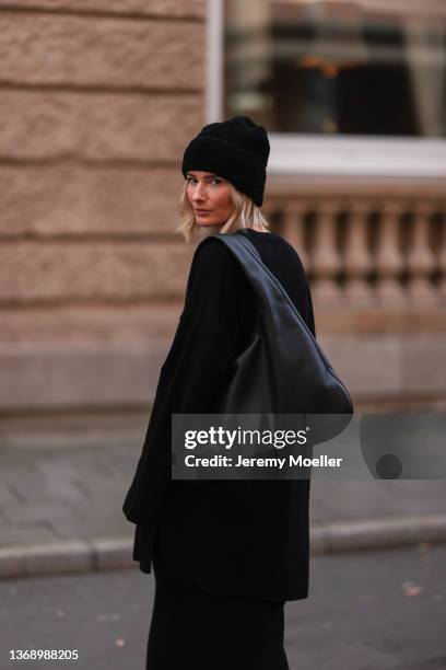 Kathrin Bommann wearing Vival Studios black knit midi dress and black maci dress, Vival Studios black hat, The Row black oversized bag on February...
