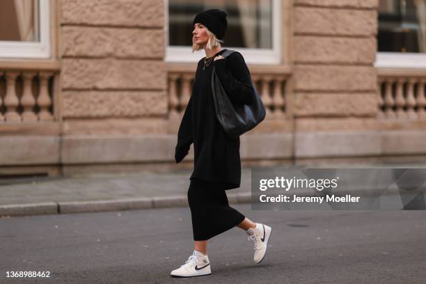 Kathrin Bommann wearing Vival Studios black knit midi dress and black maci dress, Vival Studios black hat, The Row black oversized bag on February...