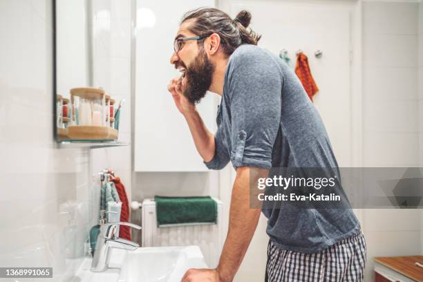 at home - young man brushing his teeth - adult in mirror stock pictures, royalty-free photos & images