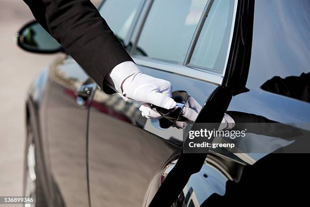 chauffeur opening / closing luxury car door - high society stock pictures, royalty-free photos & images