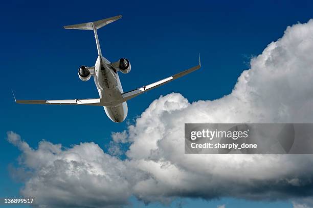 corporate jet airplane flying in cloudy sky - small jet stock pictures, royalty-free photos & images
