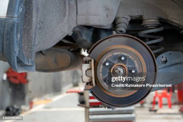 car wheel brake disc and shoes of lifted automobile at repair service station - padding 個照片及圖片檔