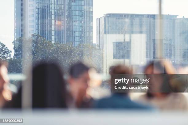 defocussed image of business people during a meeting with high rise buildings in the background. - board room background stock pictures, royalty-free photos & images