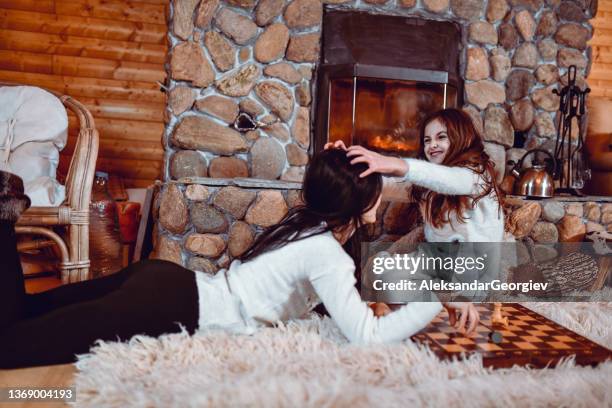 smiling female child massaging mother's head while playing chess to concentrate - queen chess piece stock pictures, royalty-free photos & images