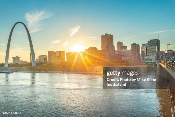 st. louis and the setting sun - views of the gateway arch stock-fotos und bilder