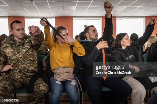 Civilians learn to use a tourniquet during medical training in a beginners combat and survival training course run by instructors from the Ukraine...