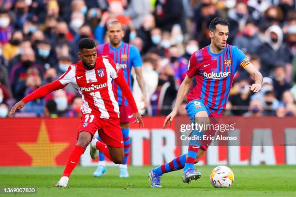 Sergio Busquets of FC Barcelona dribbles Thomas Lemar of Atletico de Madrid during the LaLiga Santander match between FC Barcelona and Club Atletico...