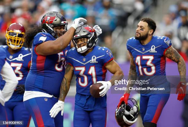 Teammates Antoine Winfield Jr. #31, Mike Evans and Vita Vea of the Tampa Bay Buccaneers and NFC react in the first half of the 2022 NFL Pro Bowl...