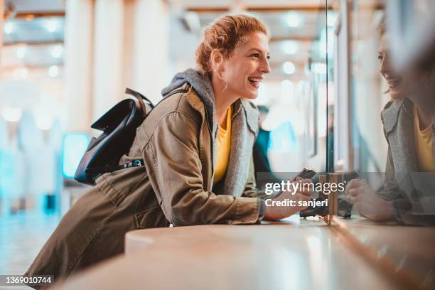 frau, die am bahnhof ein zugticket kauft - ticket stock-fotos und bilder