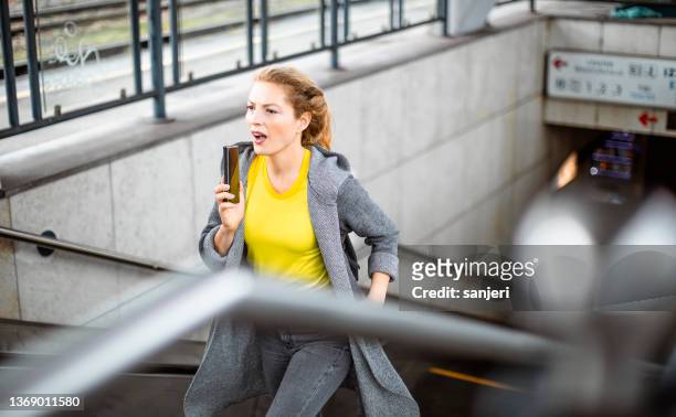 woman running up the stairs to catch the train - urgency stock pictures, royalty-free photos & images
