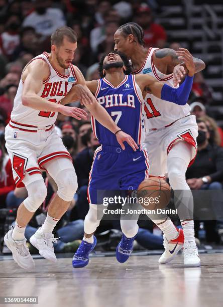 Isaiah Joe of the Philadelphia 76ers is fouled by DeMar DeRozan of the Chicago Bulls as he tries to drive between DeRozan and Matt Thomas of the...