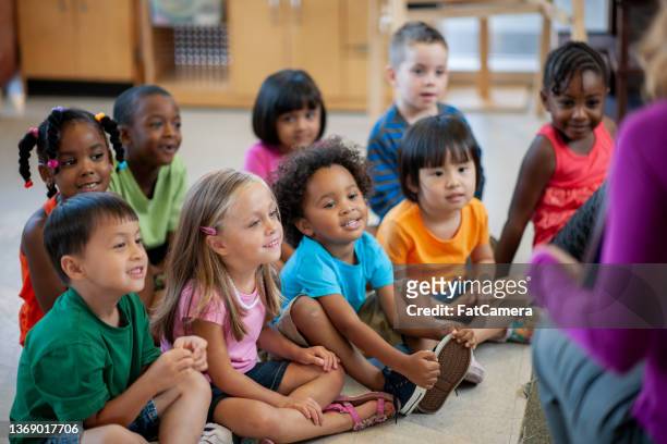 daycare teacher reading to students - kids reading in classroom stock pictures, royalty-free photos & images