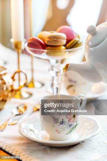 tea pouring into a cup. - english teapot stock pictures, royalty-free photos & images