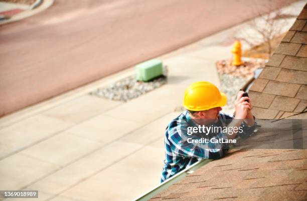 agente de seguros o techador en el techo evaluando daños a un techo - servizio fotografico fotografías e imágenes de stock