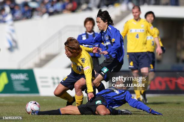 Tatsuya Yazawa of JEF United Chiba is challenged by Yasuhito Endo and Tomokazu Myojin of Gamba Osaka during the J.League J1 match between Gamba Osaka...