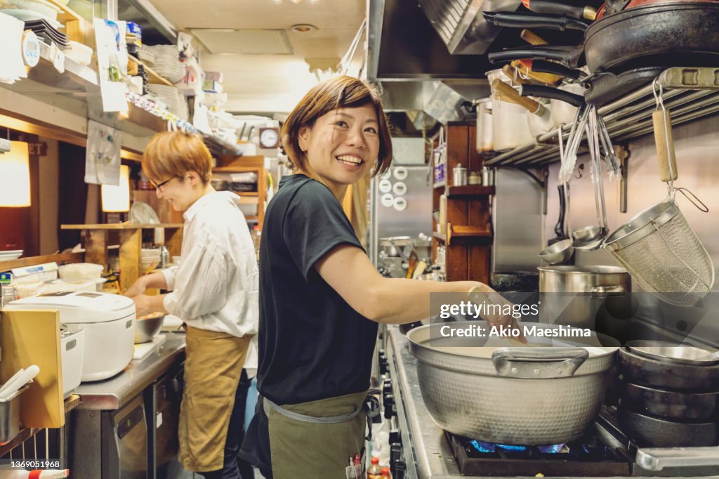 Chefs preparing food in a Japanese izakaya restaurant