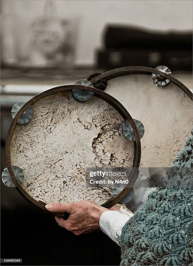 Two women playing tambourine