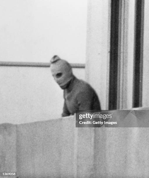 One of the eight Palestinian terrorists comprising the Black September group stands on a balcony of the Olympic village during a standoff after they...