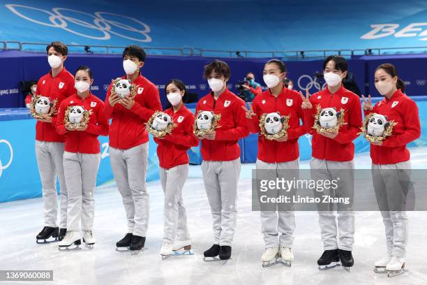 Bronze medalists Team Japan pose during the Team Event flower ceremony on day three of the Beijing 2022 Winter Olympic Games at Capital Indoor...