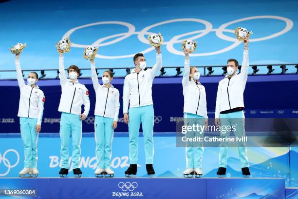 Gold medalists Team ROC pose during the Team Event flower ceremony on day three of the Beijing 2022 Winter Olympic Games at Capital Indoor Stadium on...