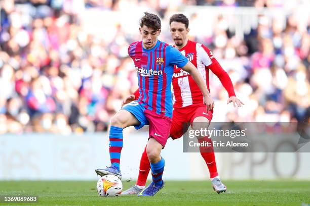 Pablo Martin Paez Gaviria 'Gavi' of FC Barcelona challenges for the ball against Stefan Savic of Atletico de Madrid during the LaLiga Santander match...