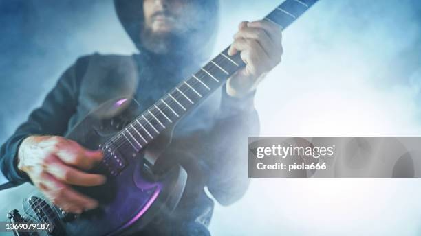 guitarrista de heavy metal rock tocando guitarra em um show ao vivo com luzes de palco - heavy metal - fotografias e filmes do acervo