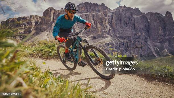 mtb mountain biking outdoor on the dolomites:enduro discipline over a single trail track - mountainbiker stock pictures, royalty-free photos & images