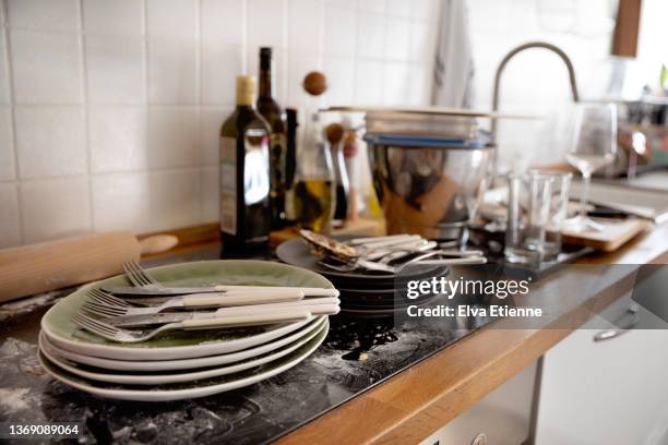 dirty dishes and cutlery on a messy kitchen counter, waiting to be washed and tidied up - dirty sink stock pictures, royalty-free photos & images