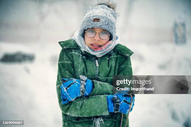 portrait of a teenage boy who is very cold during the blizzard on a winter day - beef stockfoto's en -beelden