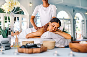 Shot of an attractive young woman lying on a bed and enjoying a massage at the spa