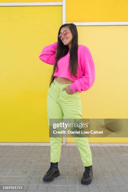 smiling irl in colorful casual clothes with red glasses on a yellow wall. - fondo amarillo stock pictures, royalty-free photos & images