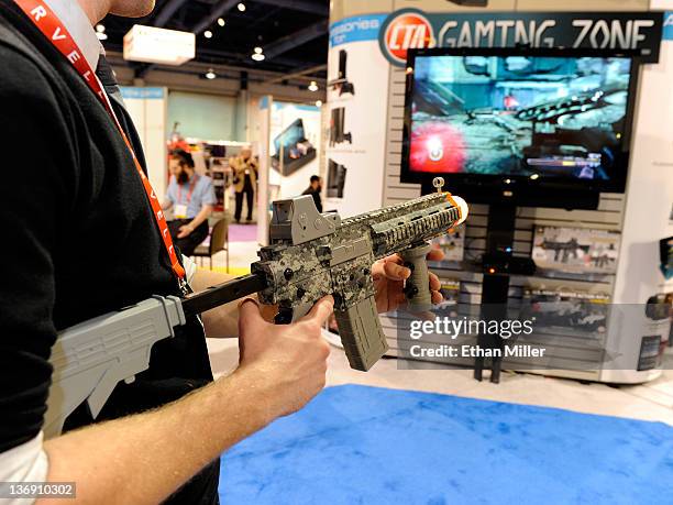 Digital's Jakub Ginda uses a U.S. Army Elite Force Assault Rifle Controller to play a video game at the CTA Digital booth at the 2012 International...