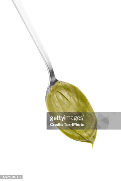 green nut butter on the spoon isolated on white background - green room stockfoto's en -beelden