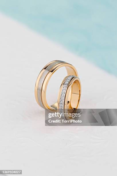 pair of unique wedding rings with diamond on white background - gold colored imagens e fotografias de stock