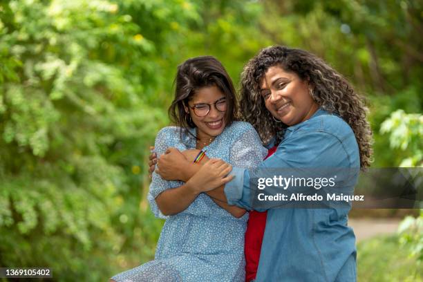 young lgbt lesbian couple embracing together at public park - fat lesbian stock pictures, royalty-free photos & images