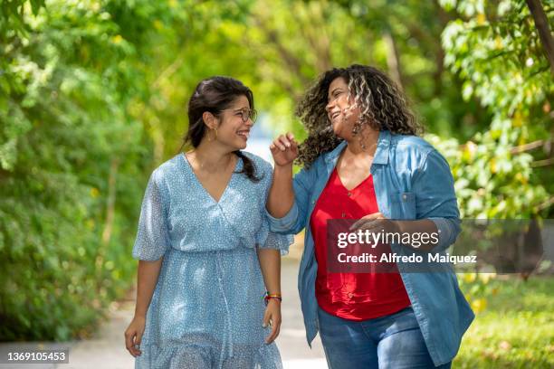 lesbian couple in latin america walking and holding hands. - mature latin women stockfoto's en -beelden