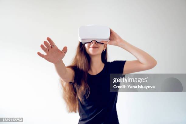 young woman is enjoying virtual reality glasses, smiling happily - virtual handshake stock pictures, royalty-free photos & images