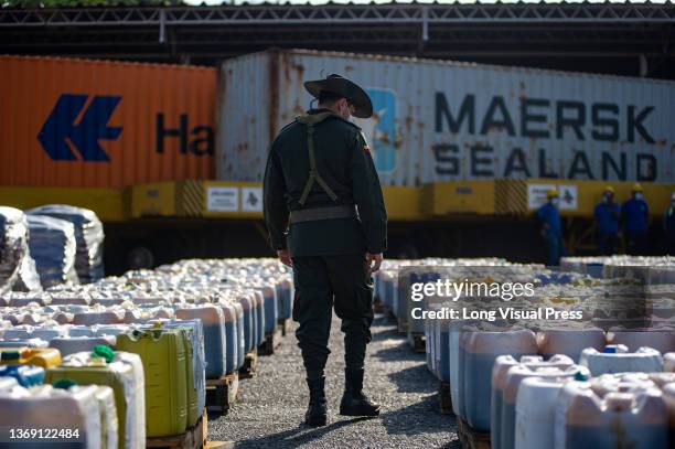 Members of Colombia's anti-narcotics police seize a cargo of molasses mixed with cocaine that was being sent to Valencia in Spain at the Ship Cargo...