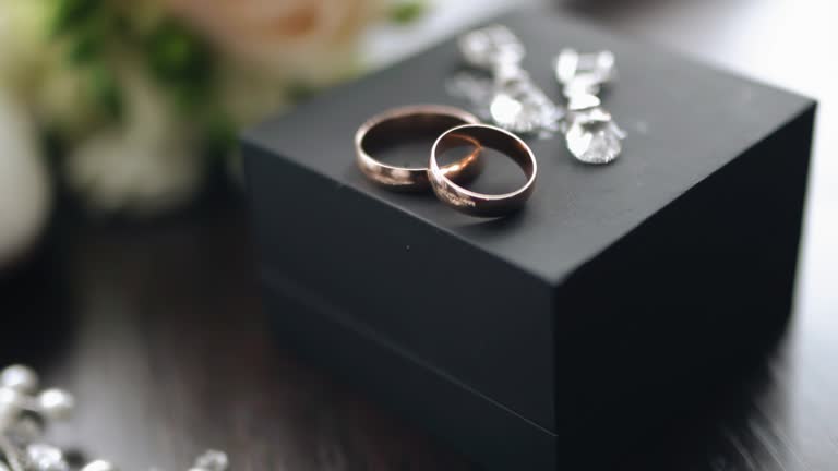 https://media.gettyimages.com/id/1369122637/video/close-up-of-two-gold-rings-lying-on-a-black-box-shooting-with-smooth-motion.jpg?b=1&s=640x640&k=20&c=-gxktLLCNz47TIwa9KSc-XRlwH5KUeb_uJ_IZItO81o=