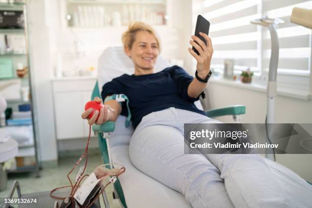 young woman is taking a selfie while donating blood - blood plasma stock pictures, royalty-free photos & images